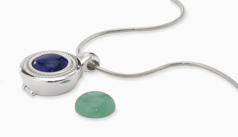 The pendant's hinged bezel opening, the stone being swapped, and the lock closing